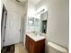 Well-lit bathroom featuring a wood vanity, a large mirror, and tiled floors at 466 Peppermill Cir, Kissimmee, FL 34758