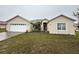 Inviting one-story home featuring an attached two-car garage and a well-maintained front yard with mature landscaping at 466 Peppermill Cir, Kissimmee, FL 34758