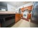 Traditional kitchen with light wood cabinets, stainless steel fridge, and black dishwasher at 466 Peppermill Cir, Kissimmee, FL 34758