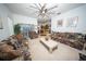 Bright living room featuring a ceiling fan, patterned sofas, and a view into the kitchen area at 466 Peppermill Cir, Kissimmee, FL 34758