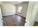 A nicely sized bedroom has wood-look flooring and a bright window at 4861 Haines Circle, Orlando, FL 32822