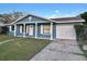 Charming single-story home with a blue exterior, white pillars, and a well-maintained front yard at 4861 Haines Circle, Orlando, FL 32822