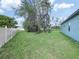 Large, grassy backyard with mature trees and a privacy fence at 509 Lakeview Dr, Poinciana, FL 34759