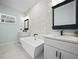 Bright bathroom featuring double vanities and a freestanding soaking tub with stylish tile at 509 Lakeview Dr, Poinciana, FL 34759