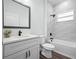 Bathroom with tiled shower/tub, white vanity, and modern black fixtures at 509 Lakeview Dr, Poinciana, FL 34759
