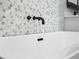 Close up of soaking tub with mosaic tile accent and sleek black hardware at 509 Lakeview Dr, Poinciana, FL 34759
