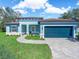 Charming one-story home with a blue exterior, paver driveway, and well-maintained landscaping at 509 Lakeview Dr, Poinciana, FL 34759