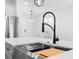 Close-up of a kitchen island with a stainless steel sink, modern faucet, and a view of the open floorplan at 509 Lakeview Dr, Poinciana, FL 34759