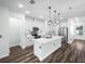 Modern kitchen featuring white cabinets, stainless steel appliances, and a center island with pendant lighting at 509 Lakeview Dr, Poinciana, FL 34759