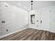 Modern living room with laminate floors, a textured white wall, and stylish pendant lighting above window at 509 Lakeview Dr, Poinciana, FL 34759