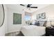 This well-lit bedroom features a ceiling fan, modern decor, and a window overlooking the neighborhood at 812 Blue Creek Dr, Haines City, FL 33844