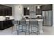 Modern kitchen with stainless steel appliances, dark cabinetry, tile backsplash, and a spacious central island at 812 Blue Creek Dr, Haines City, FL 33844