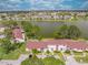 Expansive aerial view overlooking the community, lush greenery, lake, and residential homes at 86 Pine Island Cir, Kissimmee, FL 34743