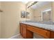 Bathroom vanity with granite countertop, wood cabinets, and illuminated mirror at 86 Pine Island Cir, Kissimmee, FL 34743