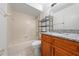 Bathroom with updated granite vanity, wood cabinets, and tiled tub with a shower at 86 Pine Island Cir, Kissimmee, FL 34743