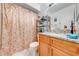 Bathroom with a vanity, granite countertop, shower with floral curtain and tile flooring at 86 Pine Island Cir, Kissimmee, FL 34743