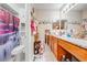 Well-lit bathroom with granite countertops, wooden cabinets, and decorative waterfall shower curtain at 86 Pine Island Cir, Kissimmee, FL 34743