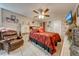 Comfortable bedroom featuring a decorative ceiling fan, patterned bedding, and a plush leather chair at 86 Pine Island Cir, Kissimmee, FL 34743