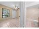Bedroom and bathroom combo featuring tile floors, ceiling fan and combination bathtub and shower at 86 Pine Island Cir, Kissimmee, FL 34743