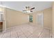 Bedroom with tile flooring, ceiling fan, and access to ensuite bathroom and walk-in closet at 86 Pine Island Cir, Kissimmee, FL 34743