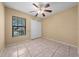 Bedroom featuring tile flooring, a ceiling fan, a window to the outdoors, and a closet at 86 Pine Island Cir, Kissimmee, FL 34743