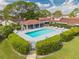 Community pool with covered area and lounge chairs surrounded by well maintained landscaping and a fence for privacy at 86 Pine Island Cir, Kissimmee, FL 34743