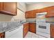 This kitchen features granite countertops, a stainless steel sink, and white appliances at 86 Pine Island Cir, Kissimmee, FL 34743