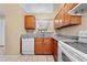Updated kitchen featuring wood cabinets, granite counters, stainless steel sink, and white appliances at 86 Pine Island Cir, Kissimmee, FL 34743