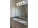 Bathroom featuring a double sink vanity with granite countertops and a large mirror at 9690 Emerald Berry Dr, Winter Garden, FL 34787