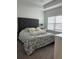 Bedroom with a large, tufted headboard, neutral walls, and natural light at 9690 Emerald Berry Dr, Winter Garden, FL 34787