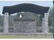 Community entrance featuring stone pillars, providing a grand sense of arrival and security at 9690 Emerald Berry Dr, Winter Garden, FL 34787