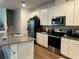 Bright kitchen featuring stainless steel appliances, white cabinets, and granite countertops at 9690 Emerald Berry Dr, Winter Garden, FL 34787