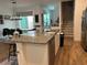 Kitchen island with stainless steel appliances and view into dining room at 9690 Emerald Berry Dr, Winter Garden, FL 34787