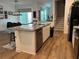 Kitchen island with stainless steel appliances and view into living room at 9690 Emerald Berry Dr, Winter Garden, FL 34787