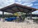 Stylish outdoor lounge area with a cozy fireplace, comfortable seating, and a shaded pergola for relaxing and entertaining at 9690 Emerald Berry Dr, Winter Garden, FL 34787