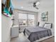 Modern bedroom with a ceiling fan, desk, and ample natural light from the large windows at 9811 Aurea Moss Ln, Orlando, FL 32832