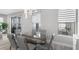 Bright dining area with a glass-top table, contemporary lighting, and views of the backyard pool at 9811 Aurea Moss Ln, Orlando, FL 32832