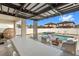 Covered outdoor patio features a large dining table, egg chair, and a swimming pool with jacuzzi and lounge chairs at 9811 Aurea Moss Ln, Orlando, FL 32832