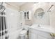 Bright white bathroom with shower-tub combo and vanity with round mirror at 1027 Banks Rose St, Celebration, FL 34747