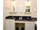 Bathroom with double vanities featuring black countertops, undermount sinks, and ample storage at 1027 Banks Rose St, Celebration, FL 34747