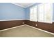 Bedroom featuring two-tone paint, neutral carpet, and bright natural light from two shuttered windows at 1027 Banks Rose St, Celebration, FL 34747
