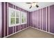 Cozy room with purple striped walls, carpet, and shuttered windows at 1027 Banks Rose St, Celebration, FL 34747