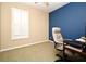A bedroom features blue accent wall, neutral walls, carpeted floors, and a desk with chair at 1027 Banks Rose St, Celebration, FL 34747