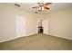 Spacious carpeted bedroom adjacent to an open bathroom offers natural light and ceiling fan at 1027 Banks Rose St, Celebration, FL 34747