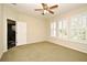 Well-lit bedroom featuring a ceiling fan and bright windows, next to an open bathroom door at 1027 Banks Rose St, Celebration, FL 34747