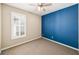 Cozy bedroom featuring tan carpet, a ceiling fan, and a blue accent wall at 1027 Banks Rose St, Celebration, FL 34747