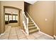 The foyer has tile floors, a staircase with white railings, and an arched doorway leading to a living room at 1027 Banks Rose St, Celebration, FL 34747