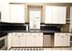 Kitchen with white cabinets and stainless steel appliances, complete with a stylish black backsplash at 1027 Banks Rose St, Celebration, FL 34747