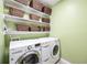 Well-lit laundry room with washer, dryer, and plenty of shelving for storage at 1027 Banks Rose St, Celebration, FL 34747