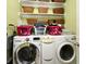 Bright laundry area boasts modern washer and dryer with shelving and basket accents for storage at 1027 Banks Rose St, Celebration, FL 34747